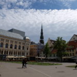 Livu Square, with old merchant houses and 100-year old buildings, plus elegant St. Peter's Church tower 